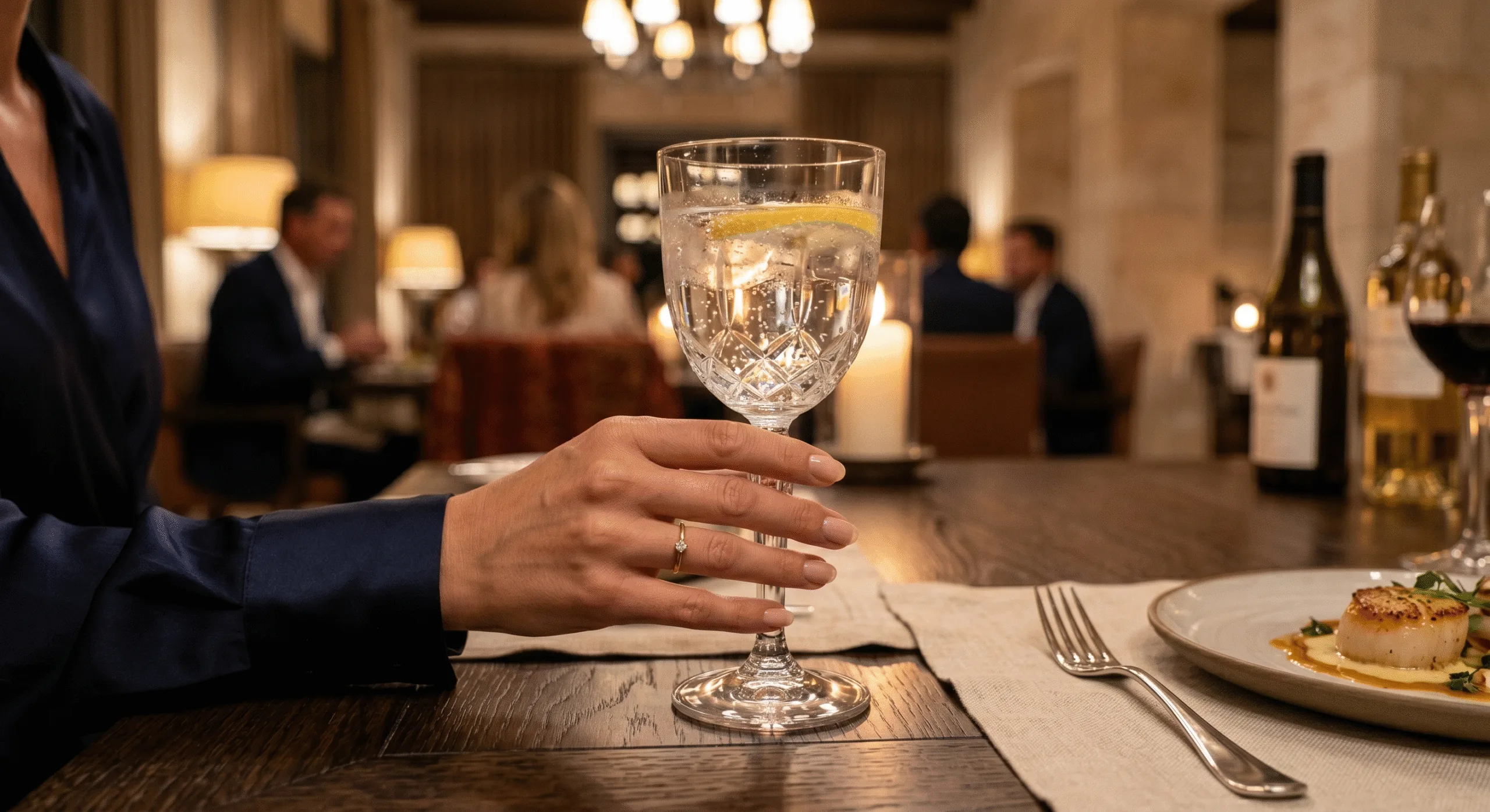 Luxury hotel guest holding premium glassware during fine dining experience