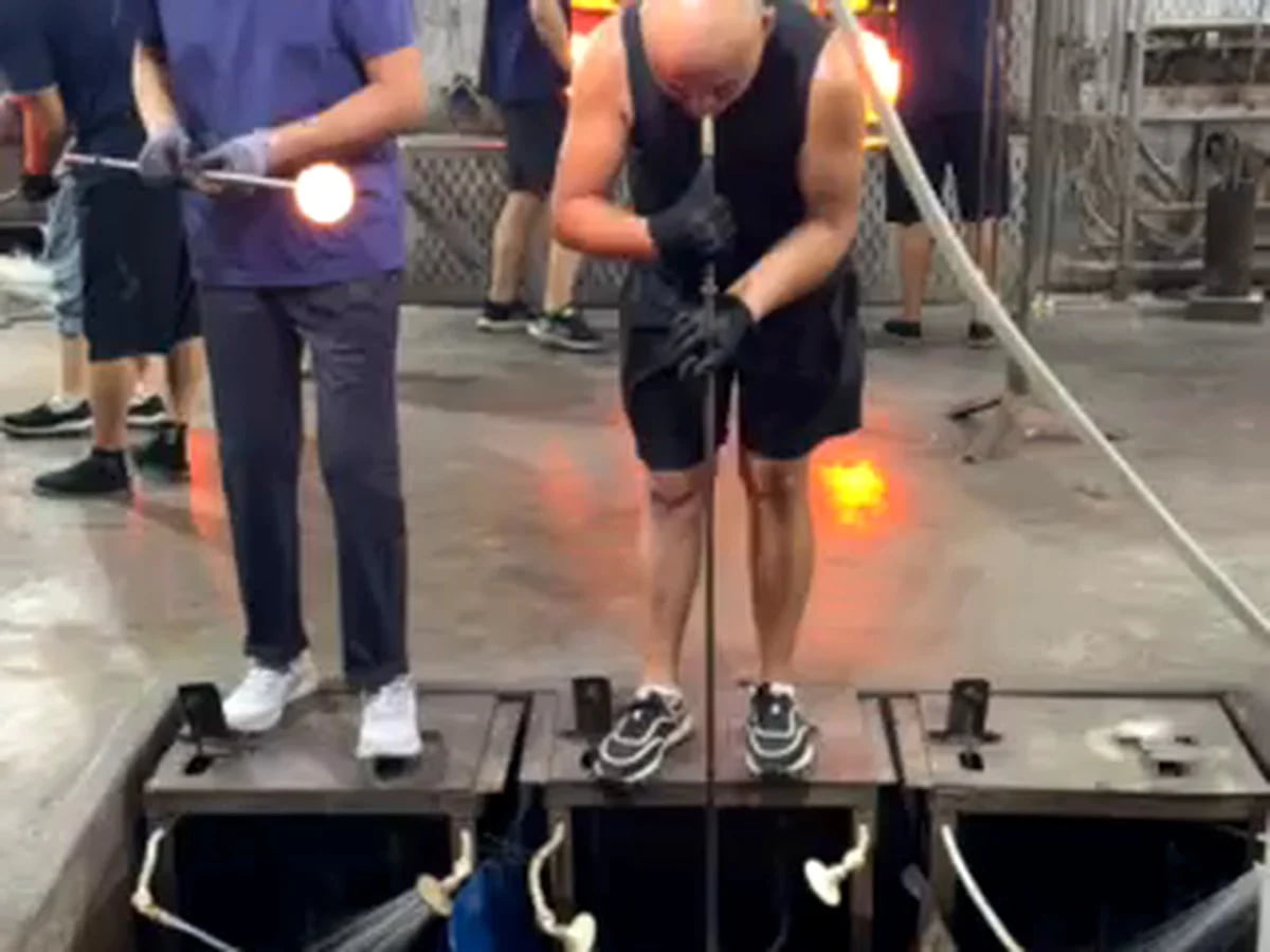 Glass artisan shaping a vessel during manufacturing